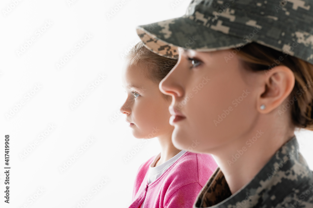 Side view of child looking away near mother in military uniform on blurred foreground isolated on white Side view of child looking away near mother in military uniform on blurred foreground isolated on white