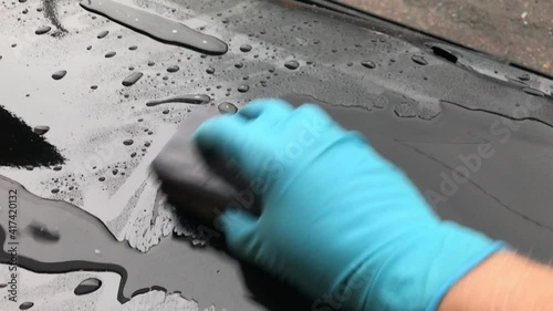 Close-up of the manual sanding of the body before polishing the paintwork.