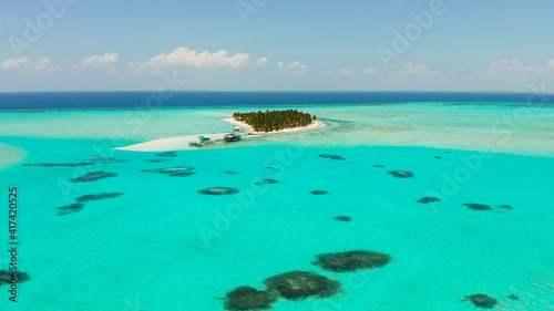 Tropical island in the ocean with palm trees on white sand beach. Onok Island, Balabac, Philippines. Summer and travel vacation concept photo