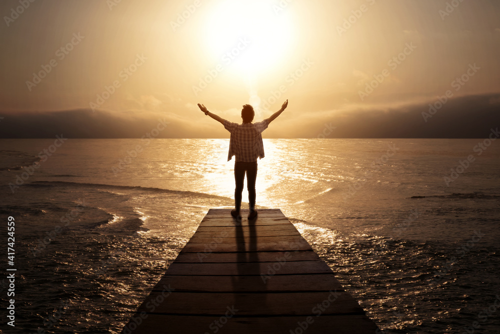 Fototapeta premium Man stretching hands while standing on the jetty