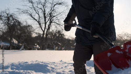 A man cleans snow with a shovel. Slow motion