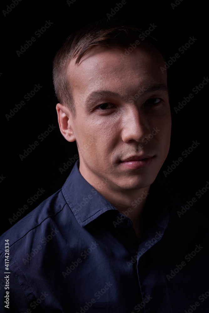 Beautiful young guy on a black background in the Studio