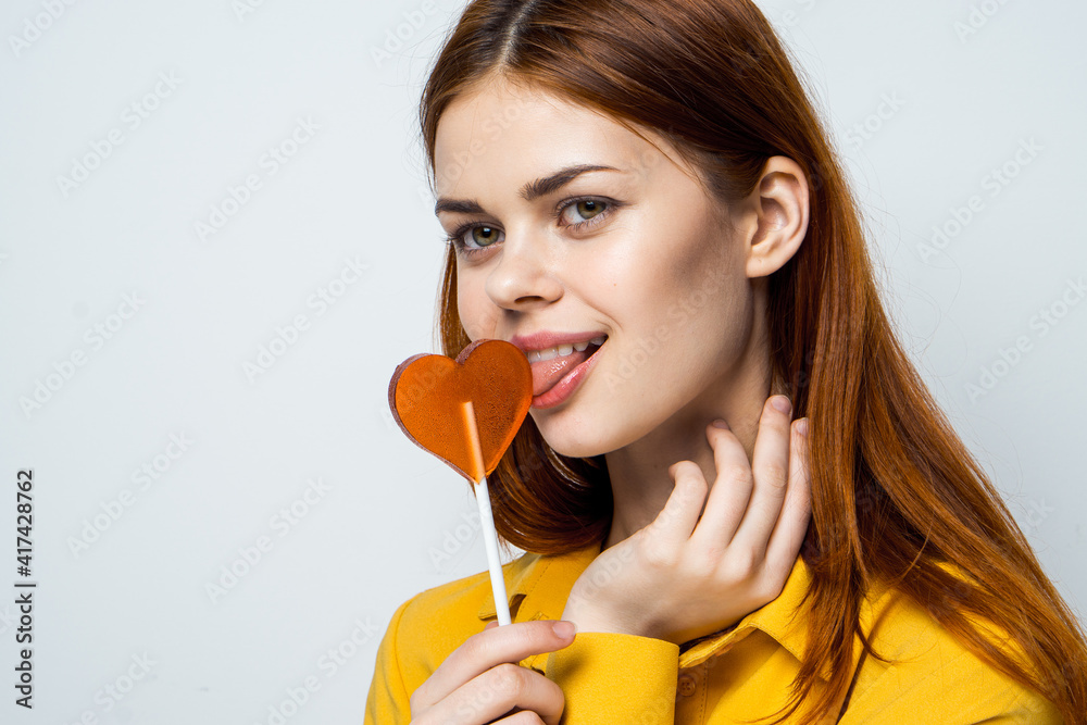 pretty woman licking heart lollipop cropped view pretty woman licking heart lollipop cropped view