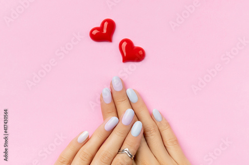 Womans hands with trendy manicure on pink background. Summer nail design