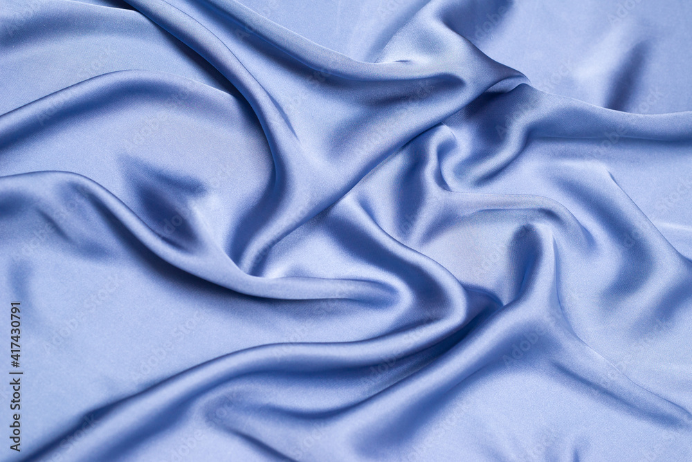 Blue silk or satin luxury fabric texture. Top view.