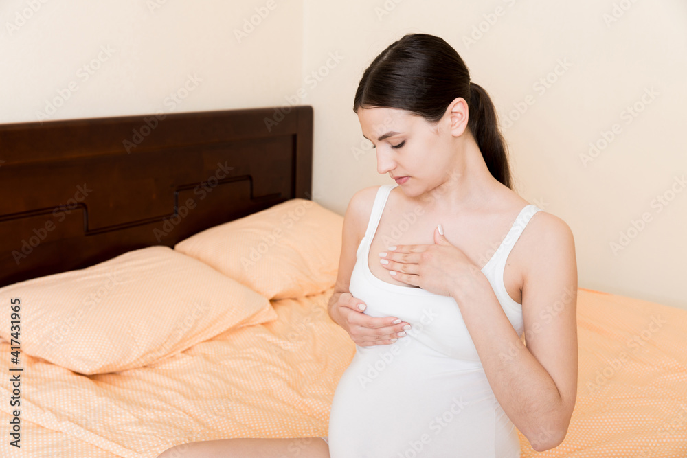 Close Up of pregnant women having painful feelings in breast. Woman checking her breast for cancer Close Up of pregnant women having painful feelings in breast. Woman checking her breast for cancer
