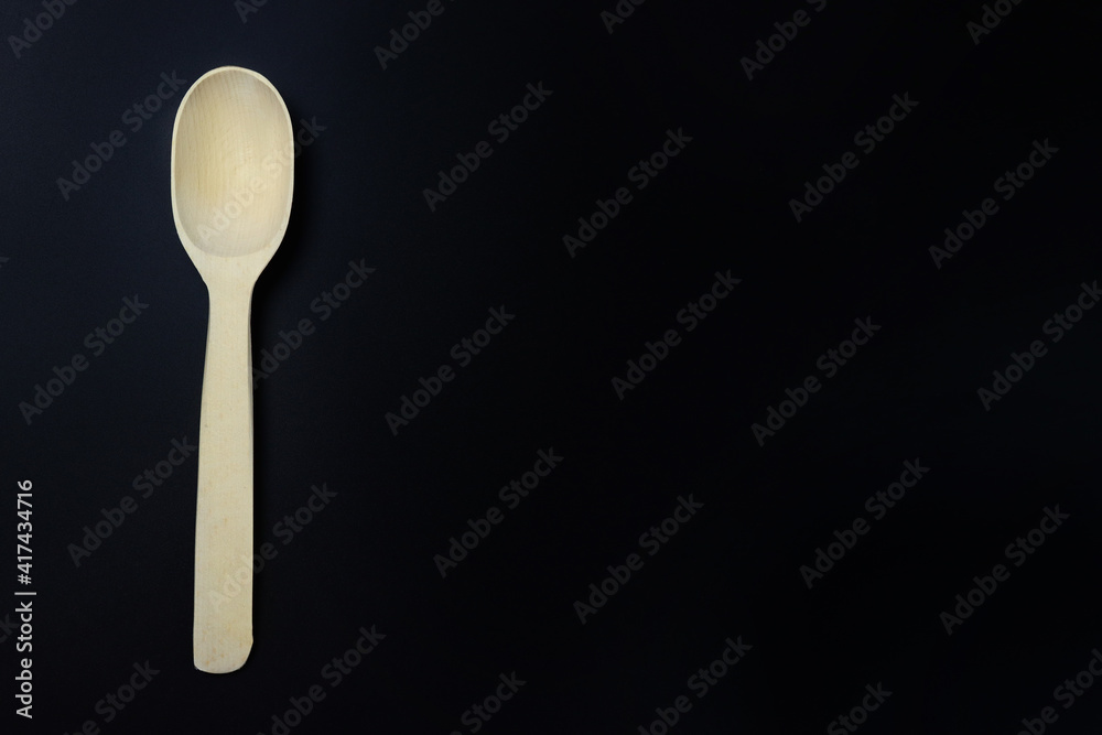 New wooden spoon on a black background. Copy space for text New wooden spoon on a black background. Copy space for text