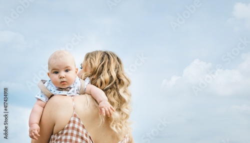 Bilde på lerret Blond mother carries her son on shoulder