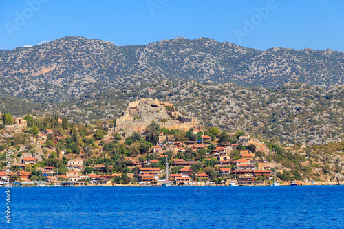 View of ancient Lycian town Simena with fortress on a mount on the coast of the Mediterranean sea in Antalya Province, Turkey