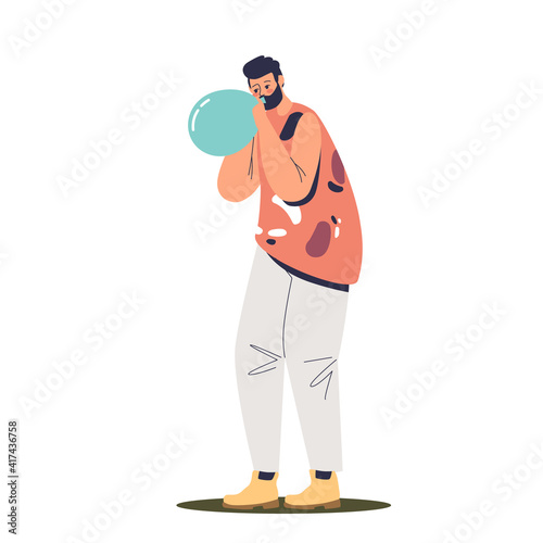 Young man blowing balloon. Hipster guy inflating air balloon for party decoration or celebration