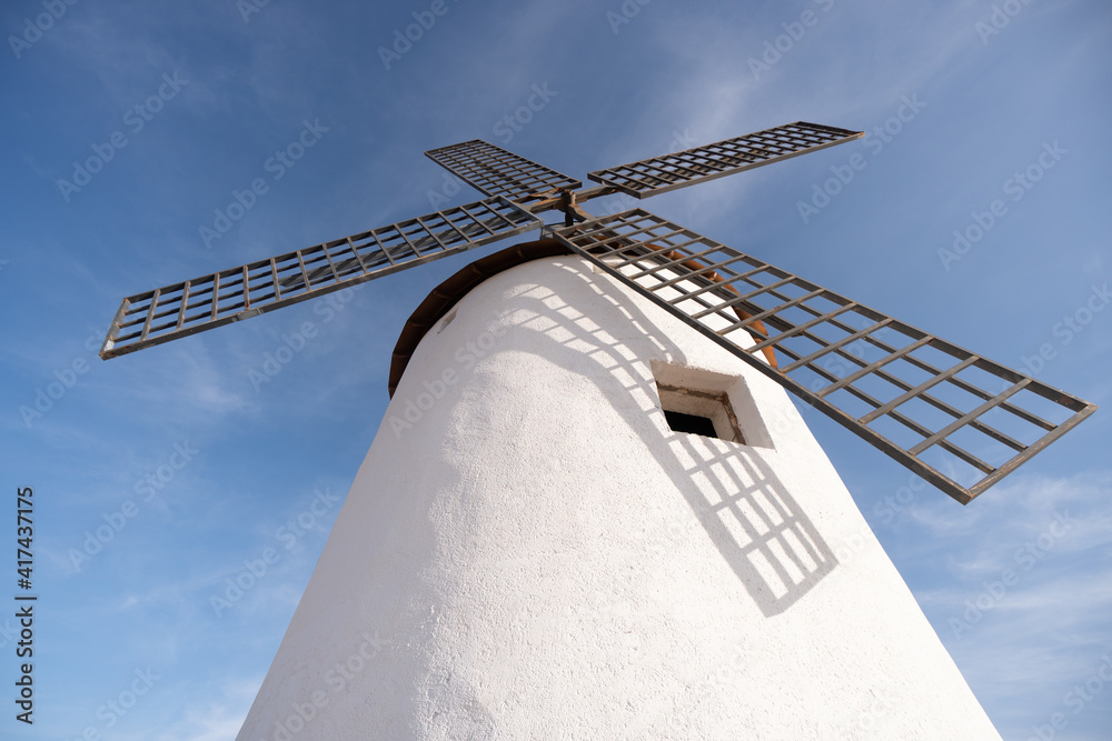 old white windmill in fields of castilla la mancha don quixote blue sky