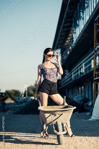 Sexy girl on construction site.Fashionable sportive girl posing