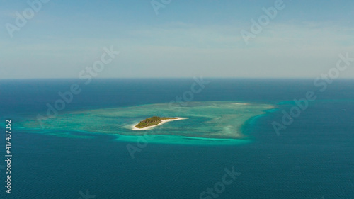 Travel concept: tropical island on an atoll with beautiful sandy beach by coral reef from above. Canimeran Island and coral reef. Summer and travel vacation concept.
