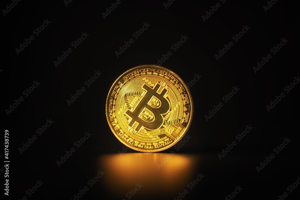 Physical shiny bitcoin agains dark background Physical shiny bitcoin agains dark background
