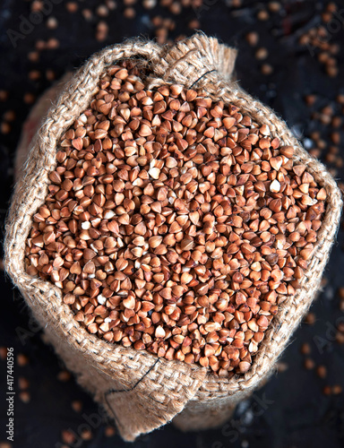 buckwheat groats in burlap sack on dark background