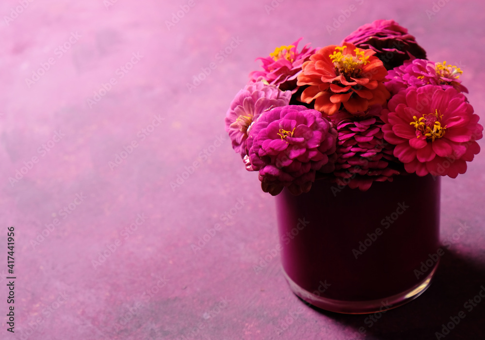 Negative space by zinnia flower vase with purple background.