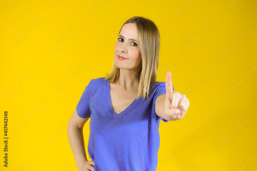Young smiling woman over isolated yellow background counting one with finger Young smiling woman over isolated yellow background counting one with finger