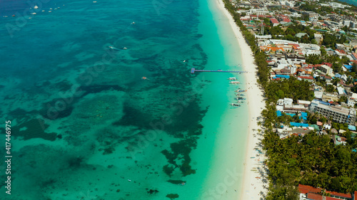 Tropical white beach with tourists and hotels near the blue sea, aerial view. Summer and travel vacation concept.