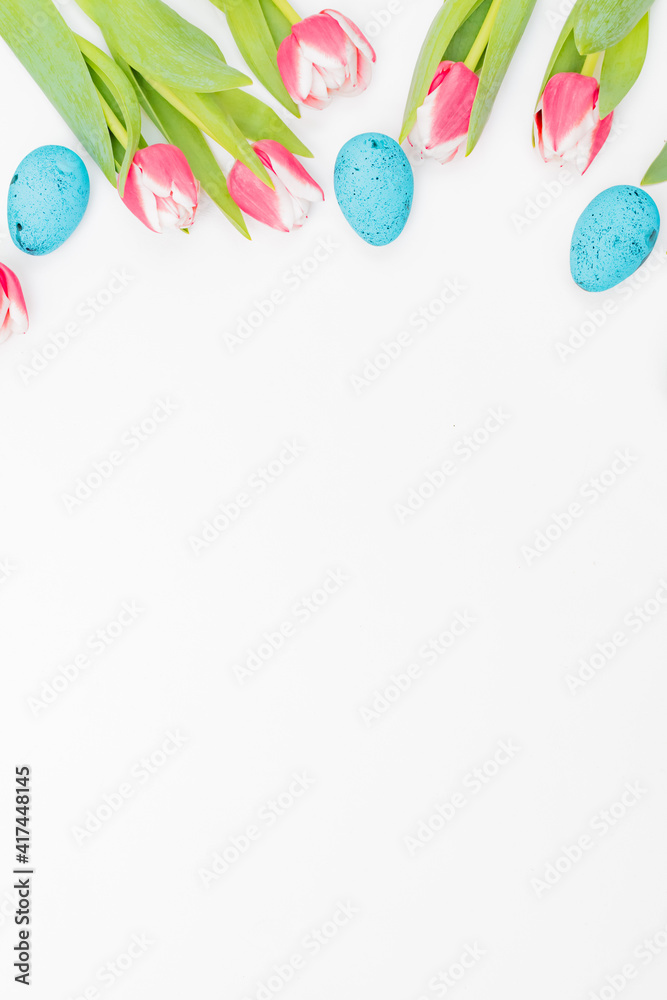 Flat lay easter composition with pink tulips and eggs on white background