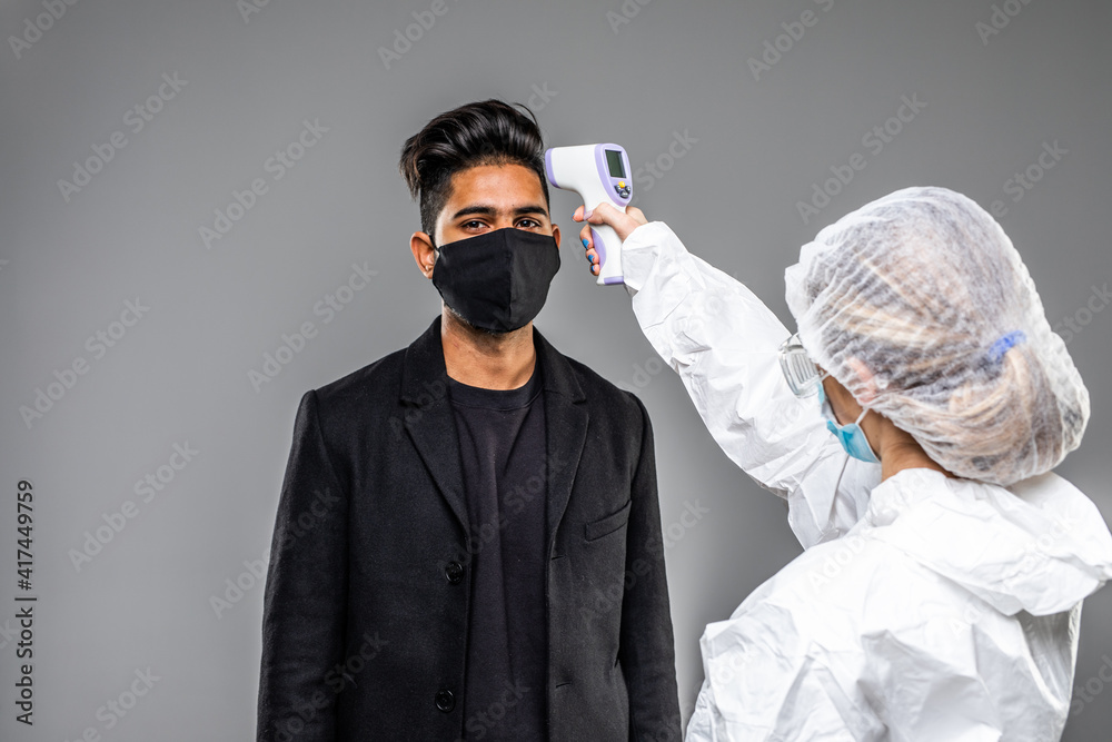 A doctor measures the temperature of a man in a medical mask. Novel Wuhan coronavirus 2019-nCoV epidemic outbreak. Medical Digital Non-Contact Infrared Thermometer, covid-19 checkpoint A doctor measures the temperature of a man in a medical mask. Novel Wuhan coronavirus 2019-nCoV epidemic outbreak. Medical Digital Non-Contact Infrared Thermometer, covid-19 checkpoint