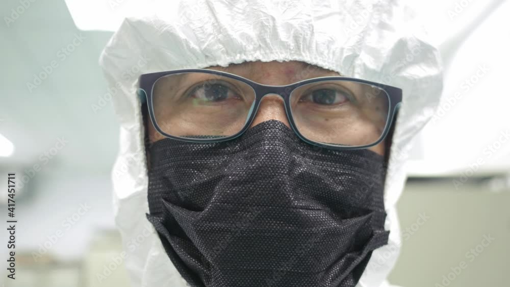 Portrait of Male scientist wearing a protective suit and mask posing in a Clean room Laboratory, CORONAVIRUS Outbreak Portrait of Male scientist wearing a protective suit and mask posing in a Clean room Laboratory, CORONAVIRUS Outbreak