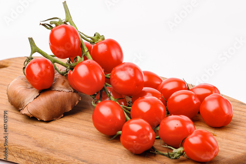 Branch of tomatoes on a wooden kitchen board
