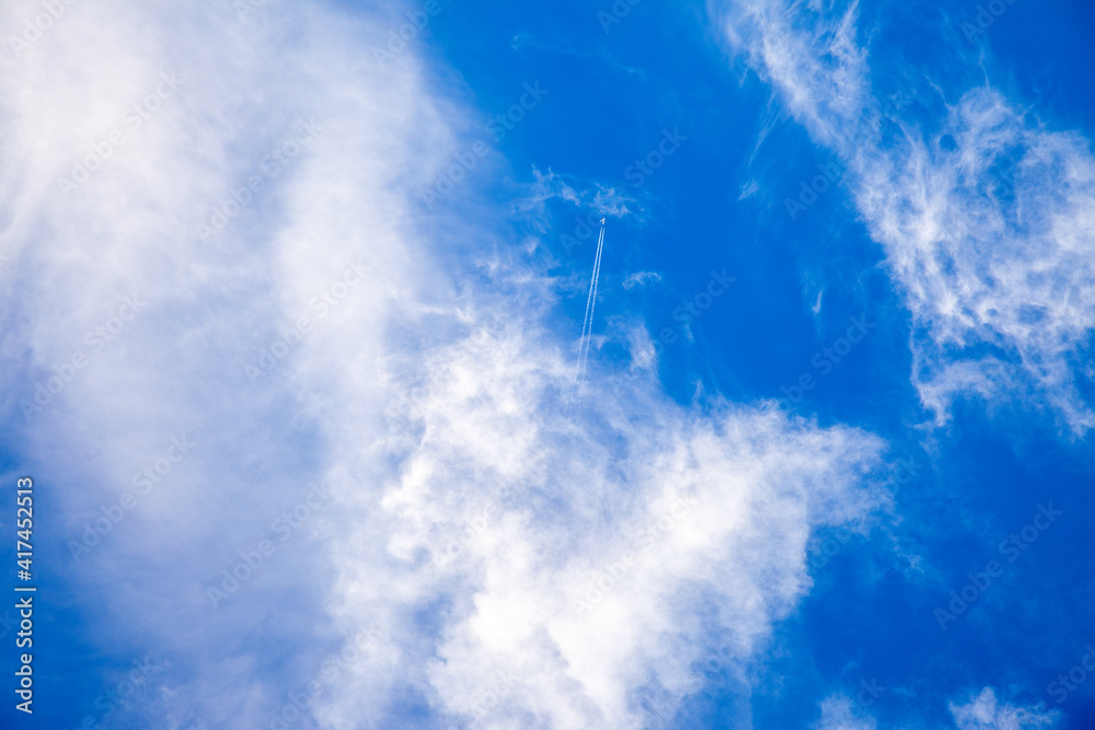 airplane in the blue sky with clouds from below, high flying passenger ...