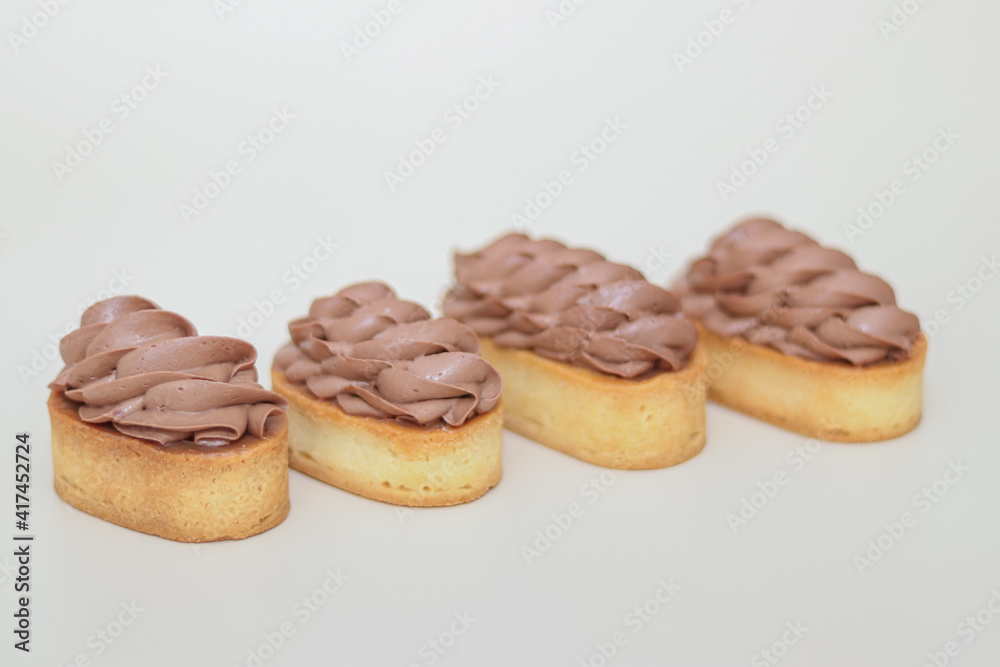 Shortcrust tartlets with chocolate cream on a light background
