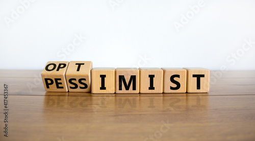 Pessimist or optimist symbol. Turned cubes and changed the word 'pessimist' to 'optimist'. Beautiful wooden table, white background. Business and optimist or pessimist concept. Copy space. photo