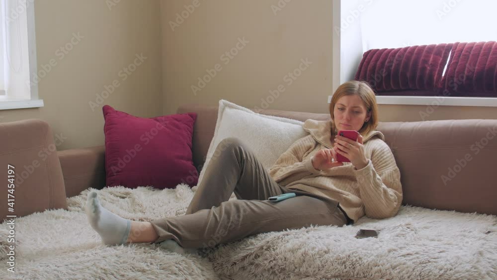 Woman on sofa resting with smartphone camera movement Woman on sofa resting with smartphone camera movement