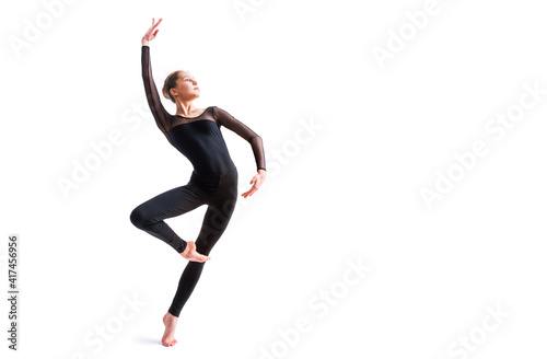Photography a ballet girl in a black tight-fitting suit dances on a white background with mo