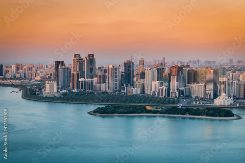 Sunset of a cityscape in urban city with red and blue contrast at sunset with a lake water view   © Ahmad Al Hussaini