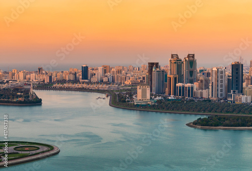 Sunset of a cityscape in urban city with red and blue contrast at sunset with a lake water view 