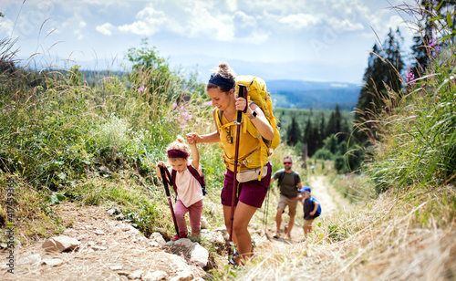 Family with small children hiking outdoors in summer nature, walking in High Tatras.