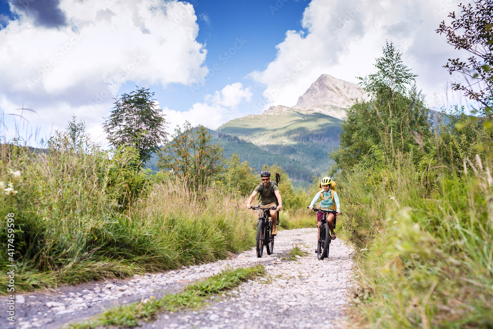 Family with small children cycling outdoors in summer nature, High Tatras in Slovakia. Family with small children cycling outdoors in summer nature, High Tatras in Slovakia.
