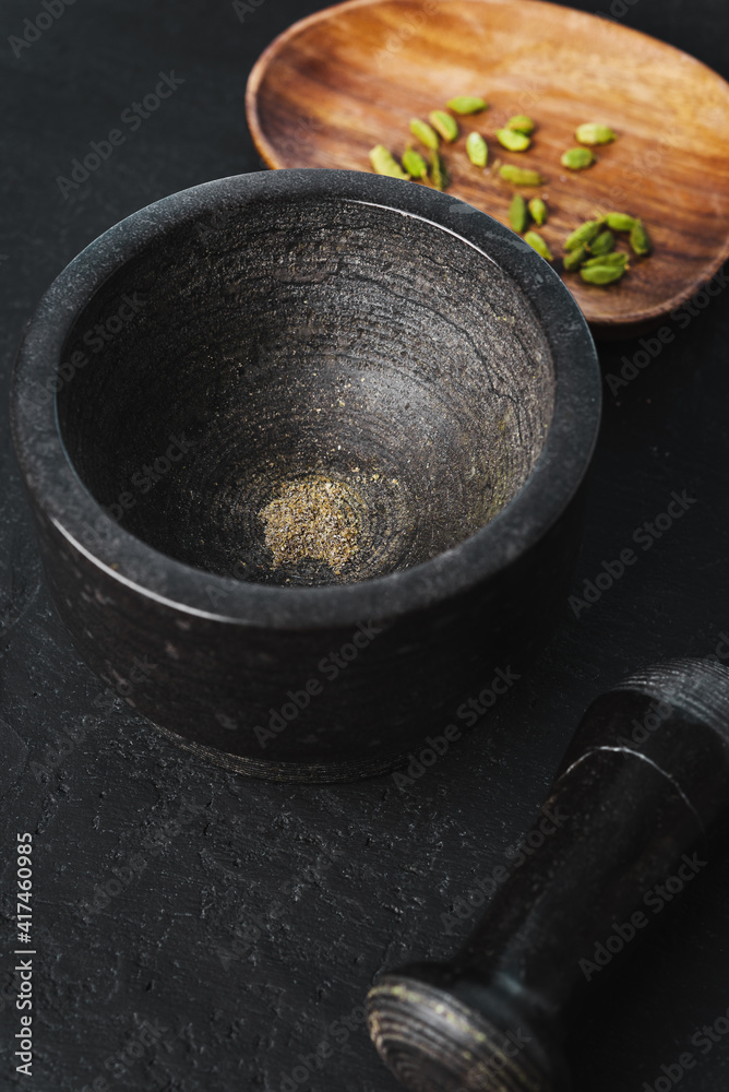 Ground cardamom in a stone frame on a black background Ground cardamom in a stone frame on a black background
