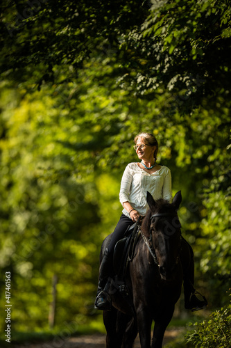 Woman riding a horse. Equestrian sport, leisure horse riding concept