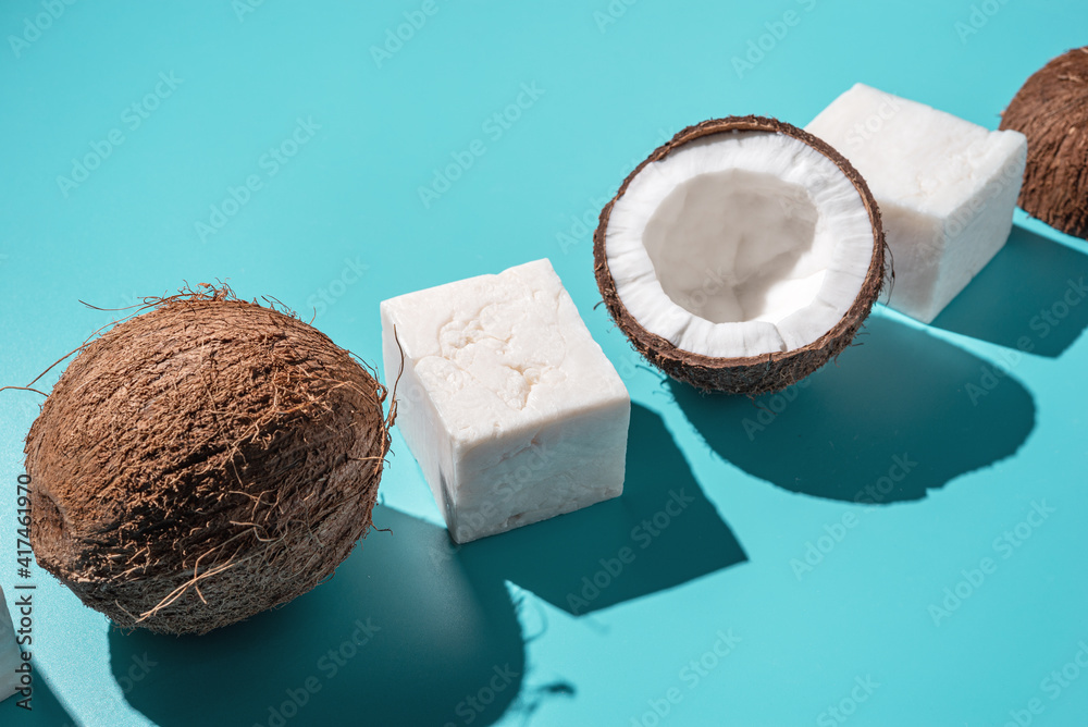 Body hygiene fatlay with coconut handmade soap and coco on blue background, hard shadow, top view Body hygiene fatlay with coconut handmade soap and coco on blue background, hard shadow, top view