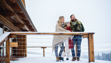 Family with small daughter on terrace outdoors, holiday in winter nature.
