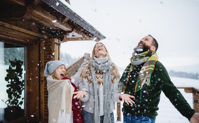 Family with small daughter having fun on terrace outdoors, holiday in winter nature.
