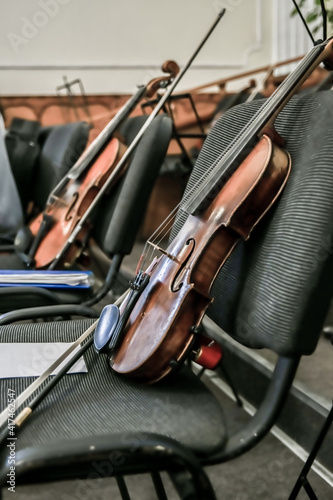 Violins stand on empty chairs of the concert hall before the start of the symphony concert.