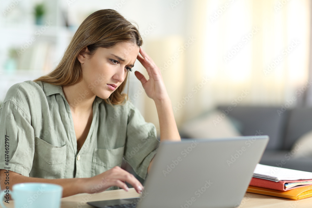 Frustrated student reading content on laptop at home Frustrated student reading content on laptop at home