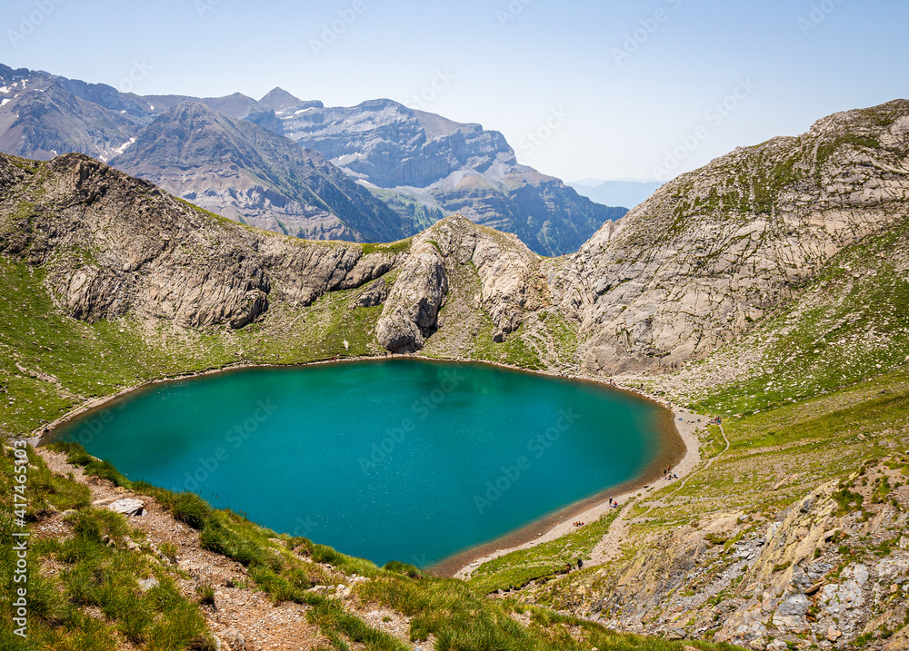 Beautiful circular lake of green water located at high altitude, surrounded by mountains in summer