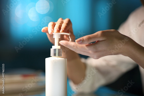 Woman hands applying moisturizer cream in the night