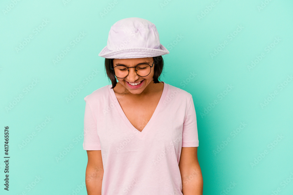 Young mixed race woman isolated on blue background laughs and closes eyes, feels relaxed and happy. Young mixed race woman isolated on blue background laughs and closes eyes, feels relaxed and happy.