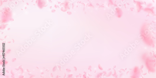 Sakura petals falling down. Romantic pink flowers frame. Flying petals on pink wide background. Love