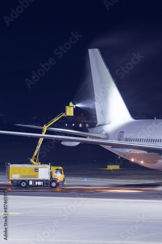 Aircraft de-icing operation at airport at night