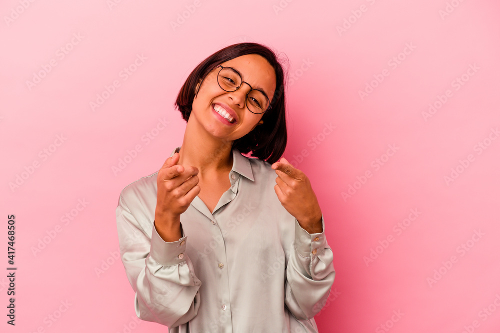 Young mixed race woman isolated on pink background cheerful smiles pointing to front.