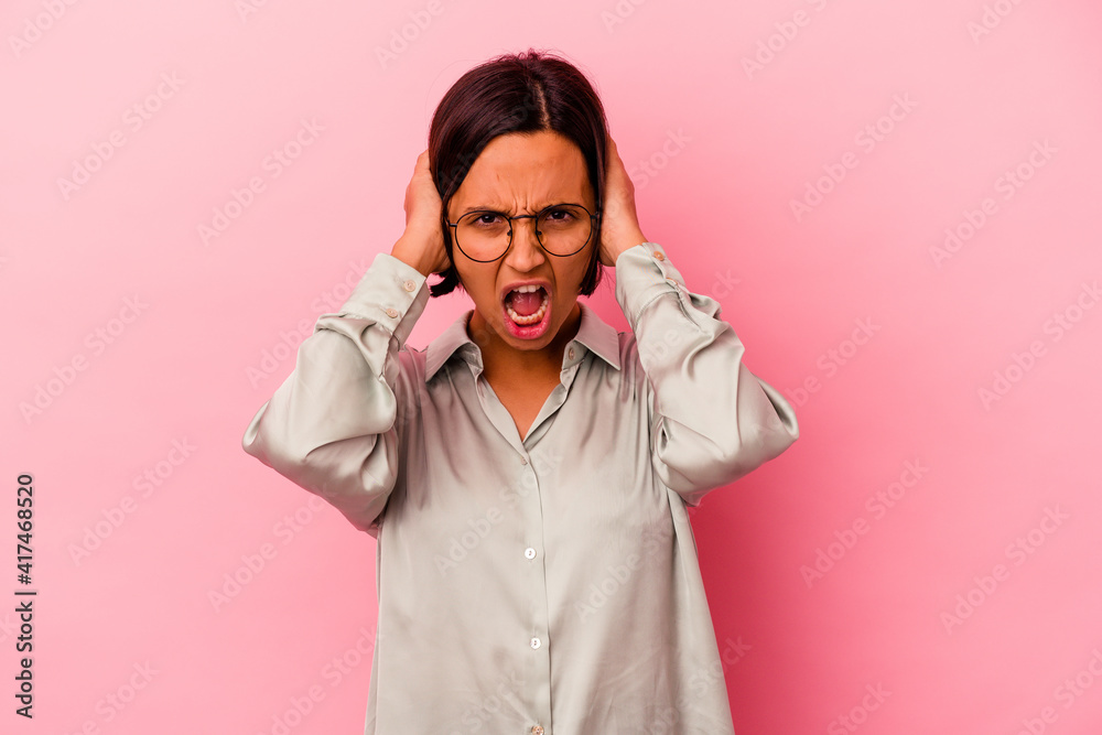 Young mixed race woman isolated on pink background screaming with rage. Young mixed race woman isolated on pink background screaming with rage.
