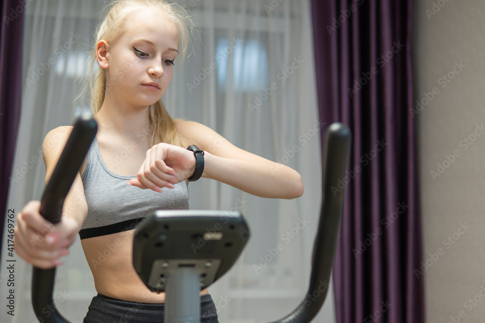 girl doing fitness on an exercise bike at home. high quality girl doing fitness on an exercise bike at home. high quality